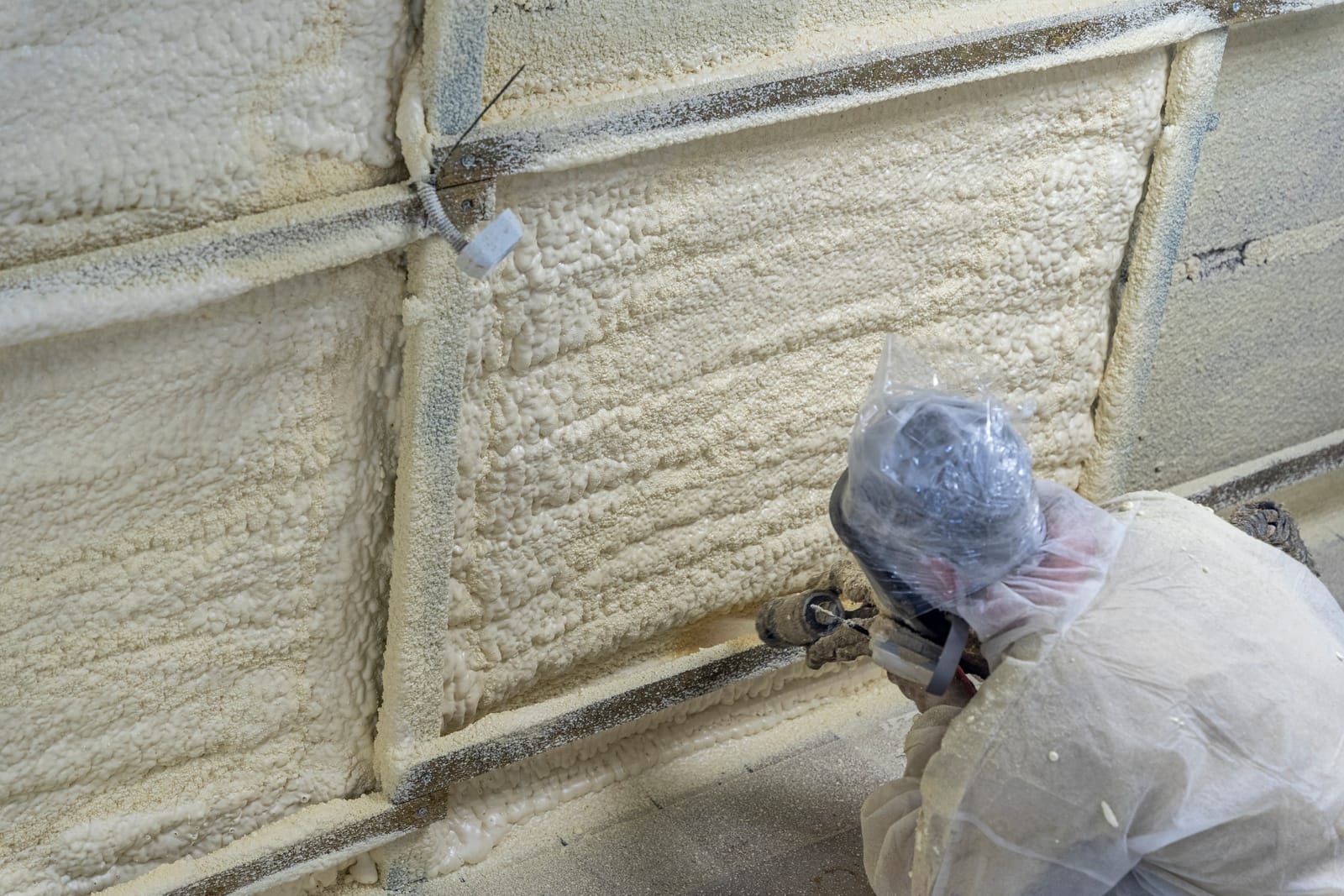 worker-in-a-protective-suit-insulates-the-walls-with-polyurethane-foam